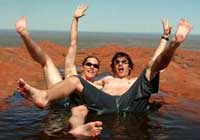 Ill. 37: Two tourists lying in a small puddle on top of Uluru.